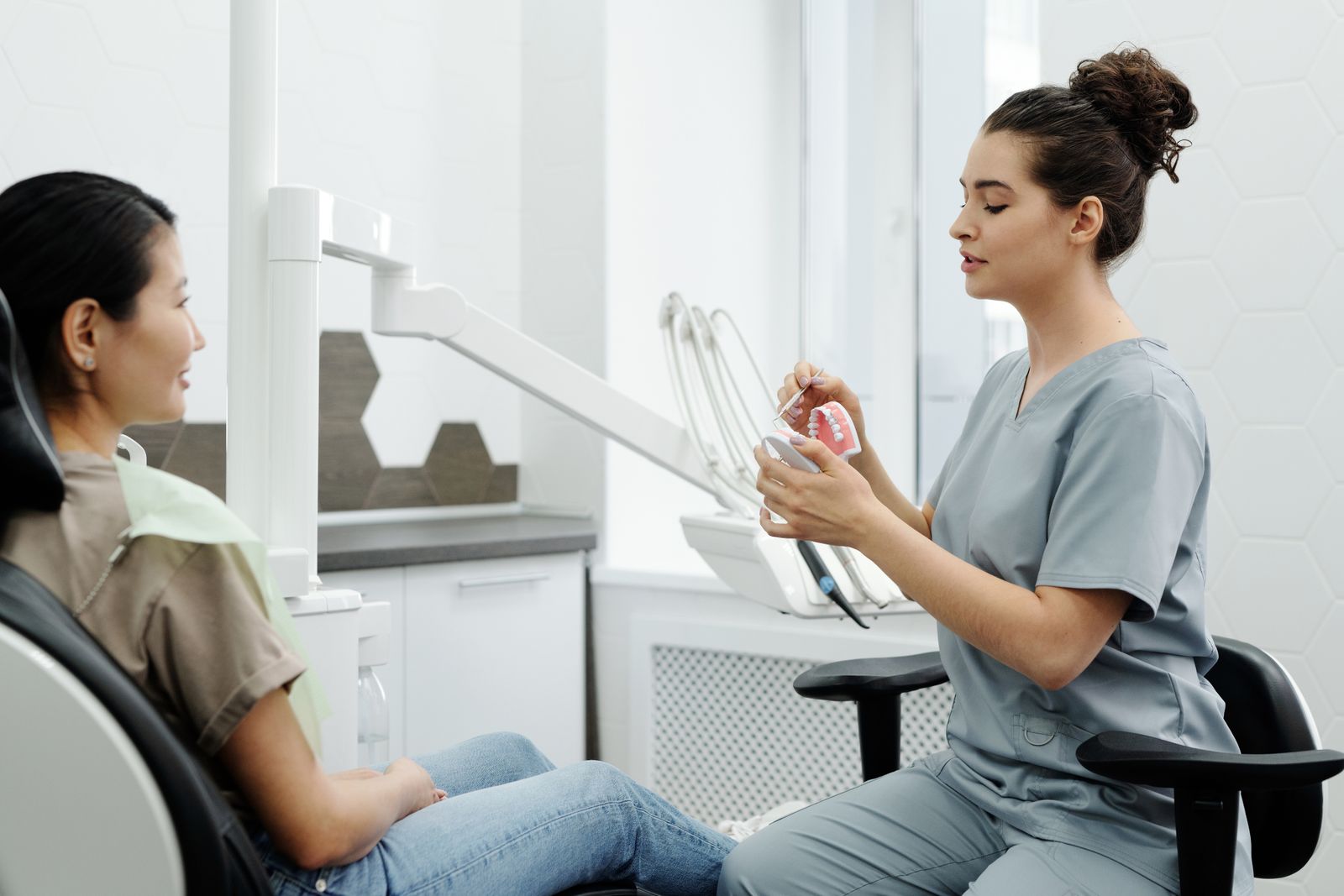 Dentist explaining a tooth model to a patient